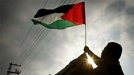 A Palestinian security man raises a flag at a Gaza security post.