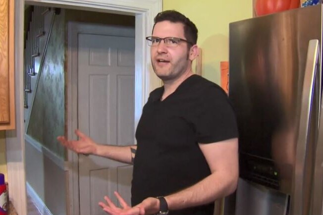 Nate Roman stands in his kitchen and shrugs his shoulders.