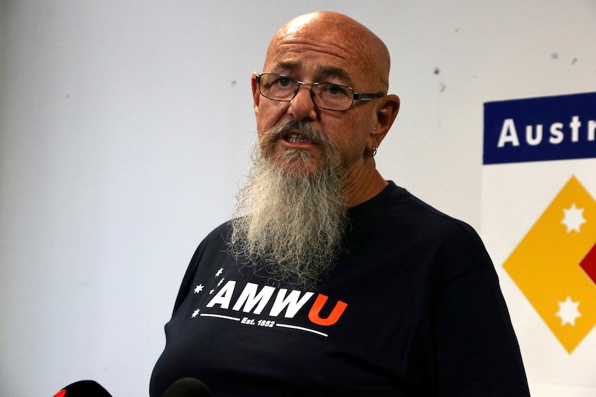 Head shot of a bearded man wearing glasses an an AMWU t-shirt