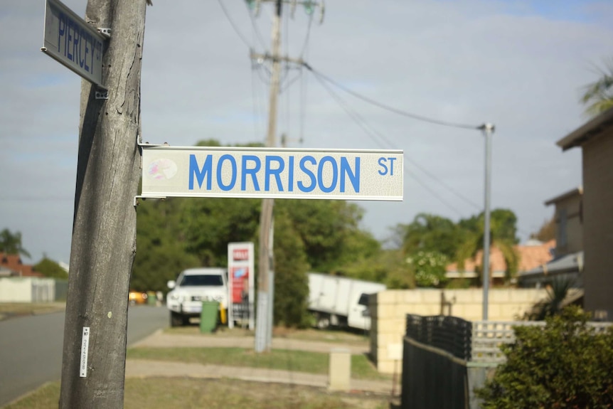 A street sign that says "Morrison St" attached to a pole by the road side.