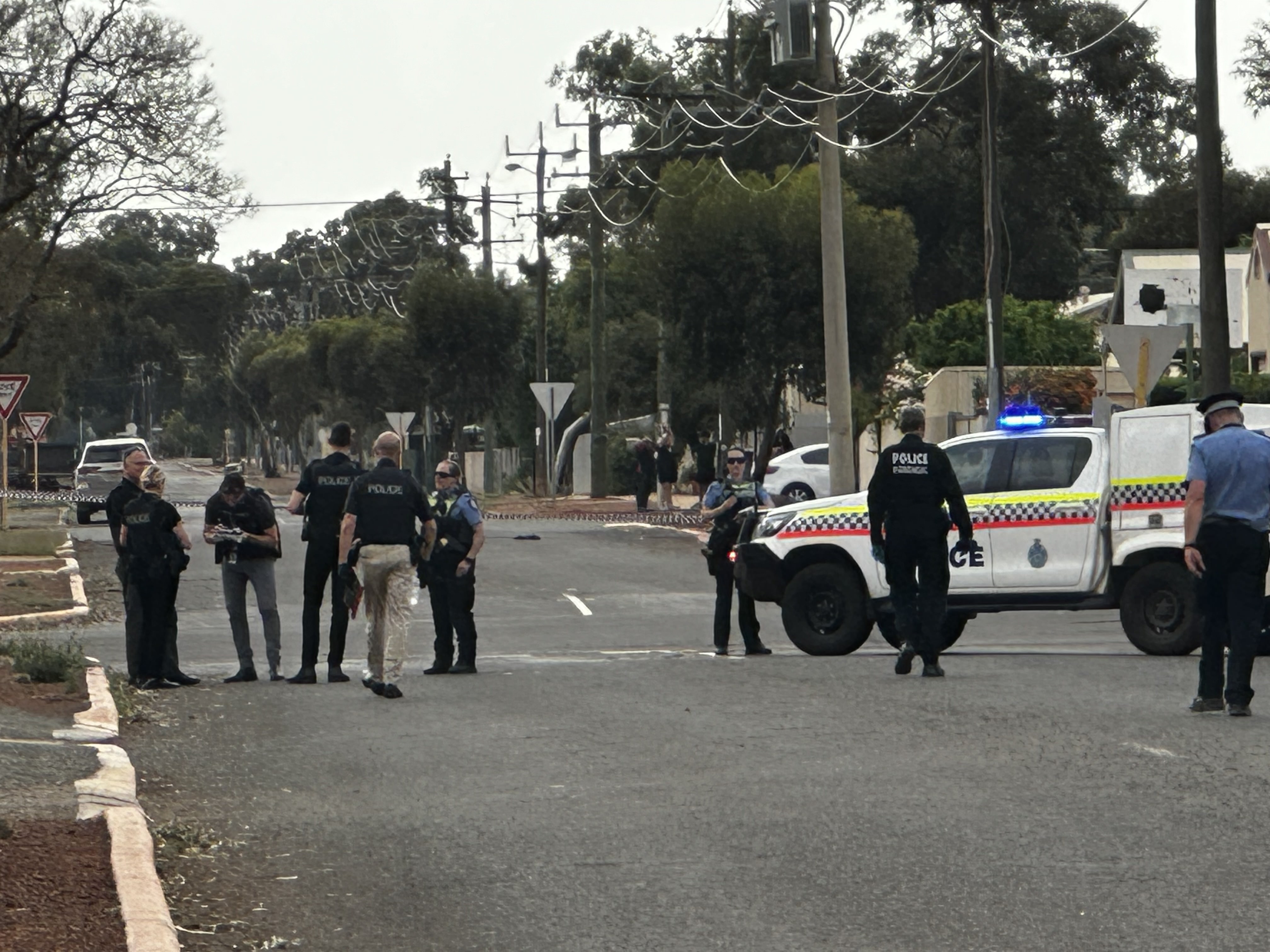 Police stand along a road 