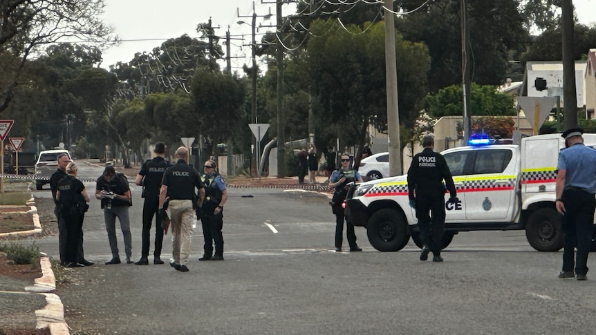 Police stand along a road 