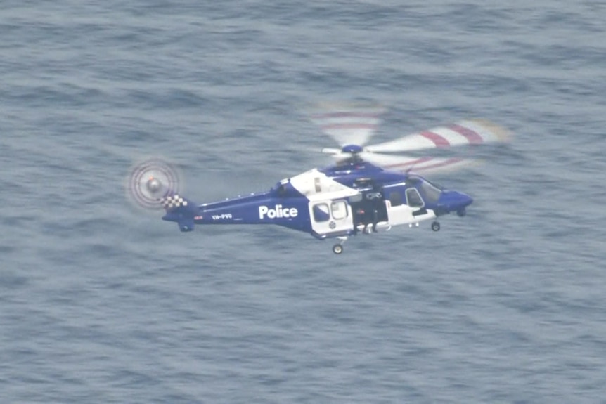 A police helicopter flying above the sea.