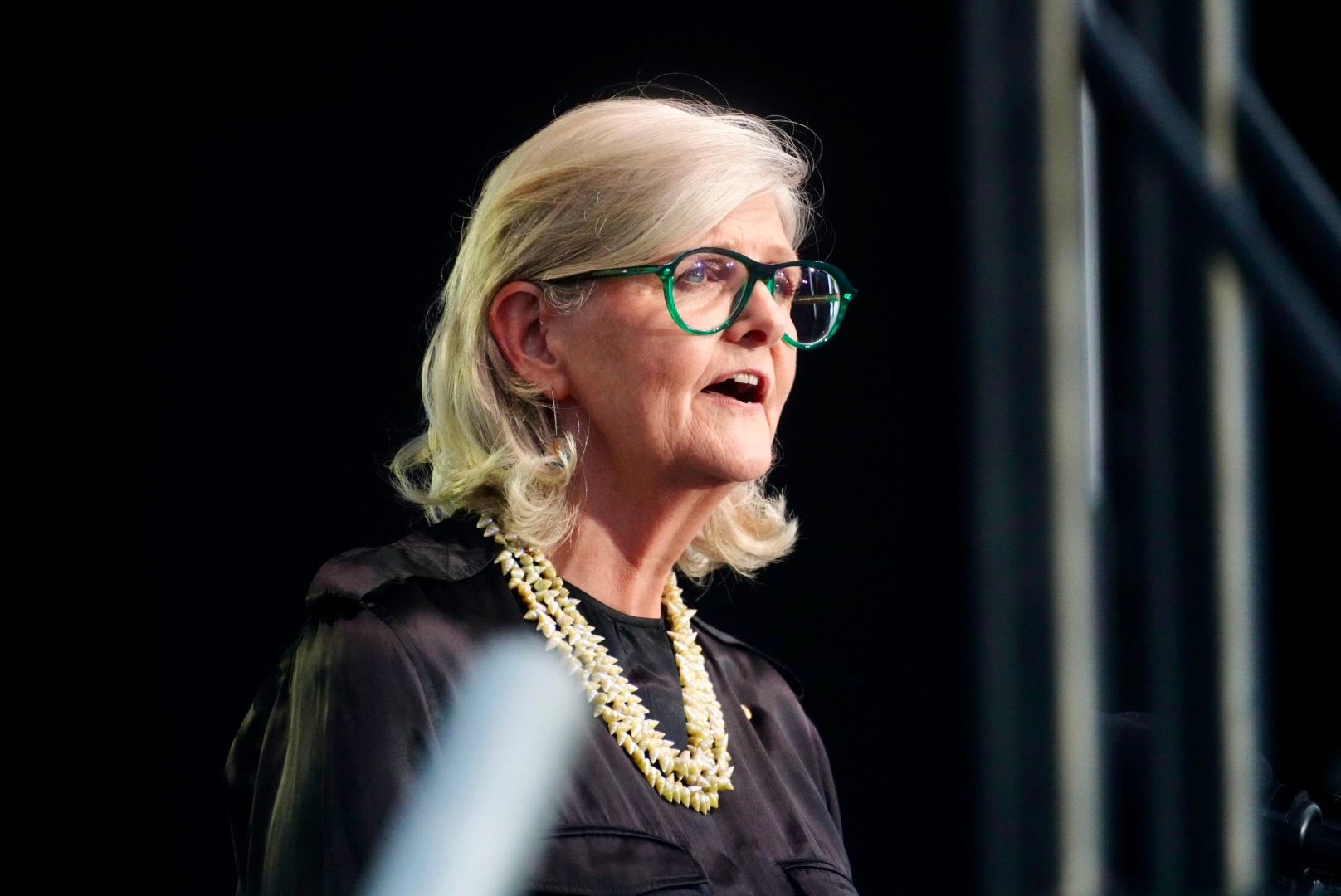 Sam Mostyn faz um discurso em um púlpito no palco.