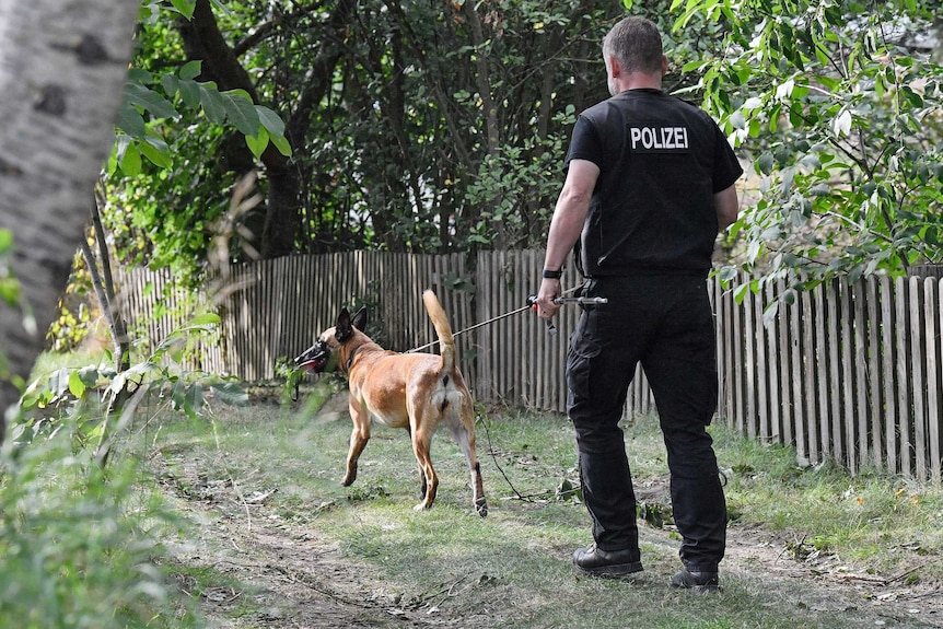A German police officer walks with a search dog.