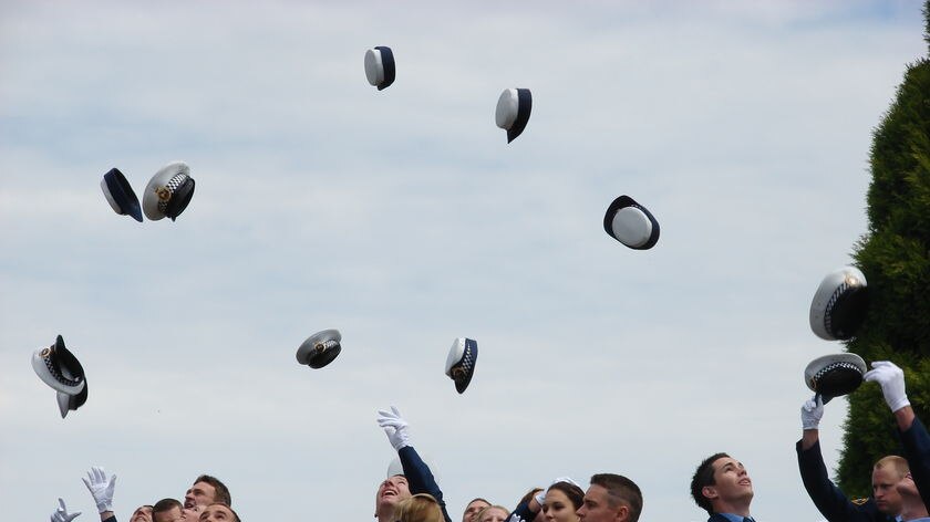 Graduates from the Rokeby Police Academy throw their hats in the air.