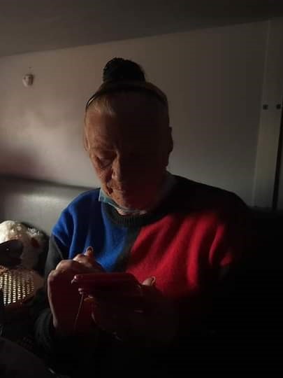 a woman sits on a dark train carriage