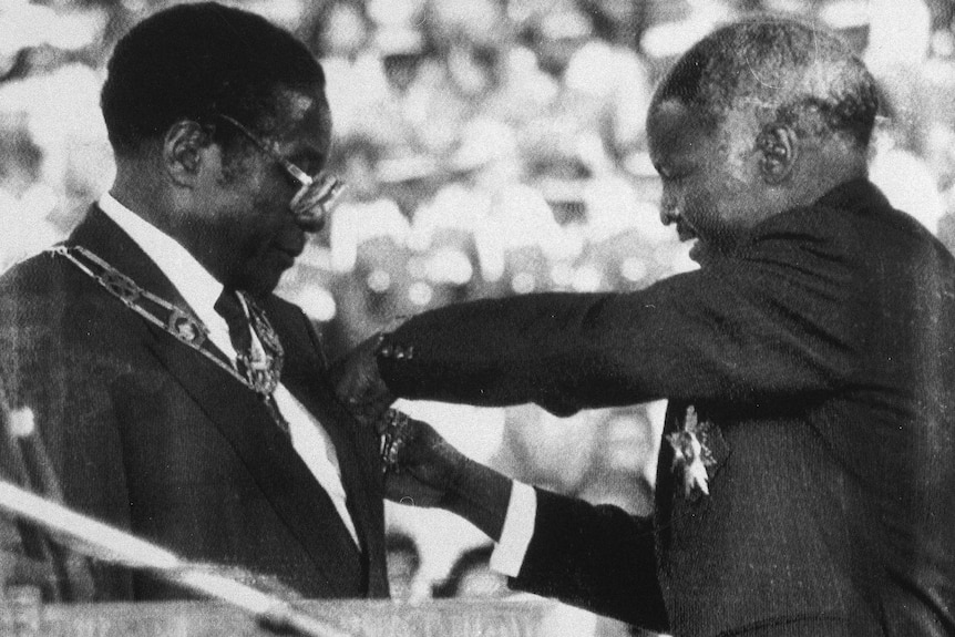 Robert Mugabe is sworn in as Zimbabwe's first executive president by former president Canaan Banana.