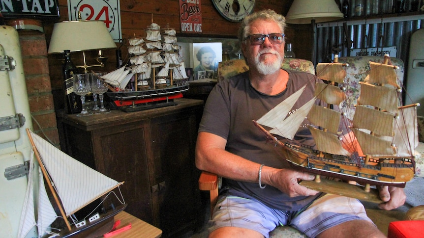 A man holds a model tall ship
