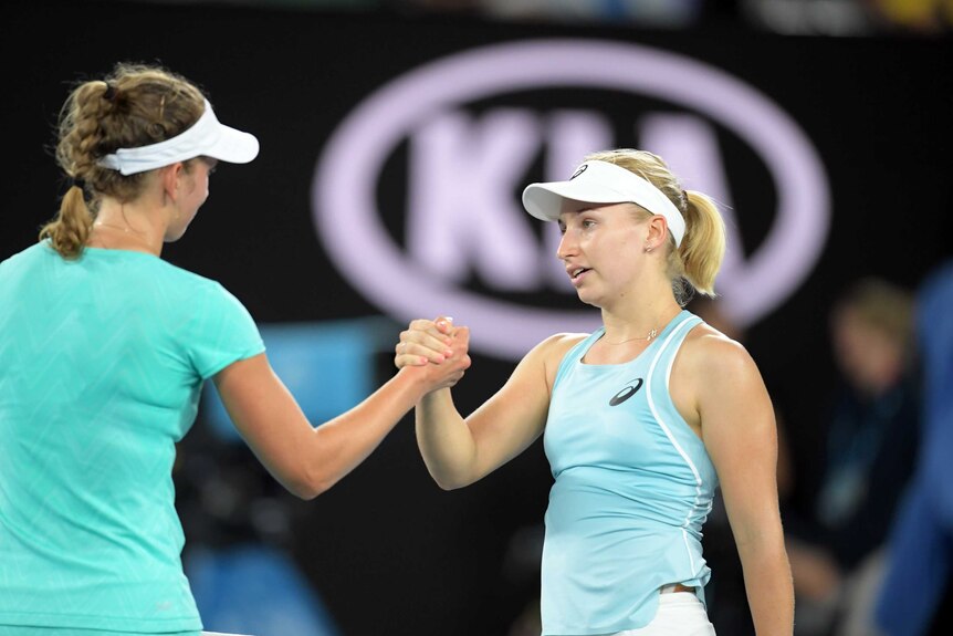 Elise Mertens, who has her back to the camera, shakes hands with Daria Gavrilova.