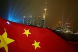 Close-up of China's flag in front of the Shanghai city skyline.