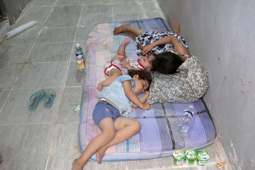 Surviving migrants rest at a detention centre