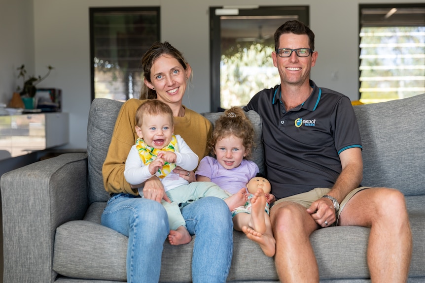 Kara and Jack Page pictured on their couch with their children Hayley and Lachy. 