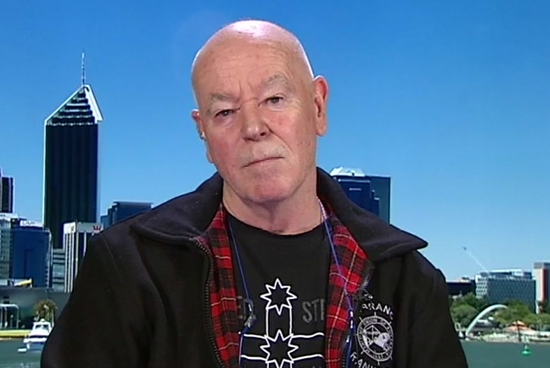 Christy Cain sits with the Perth skyscape behind him