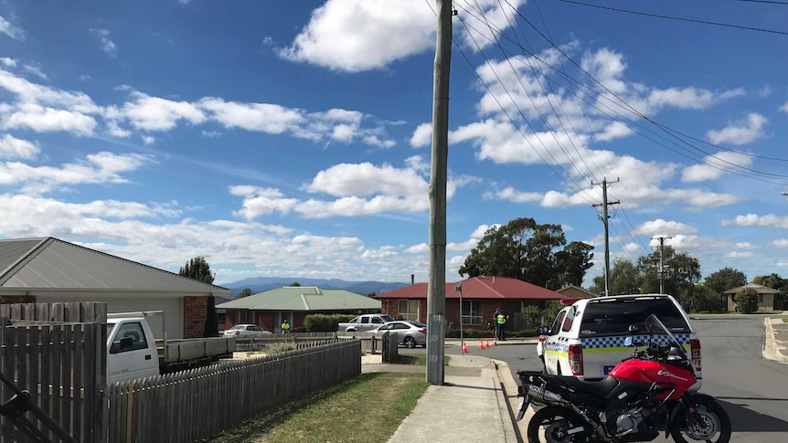 Police vehicles blocking an intersection where a man died in a hit-and-run crash.