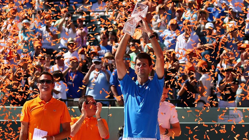 Novak Djokovic holds the Butch Bucholz trophy aloft after beating Andy Murray to win the Miami Open.