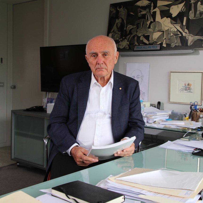 Allan Fels in an office with documents 