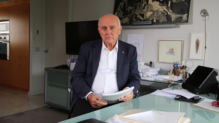 Allan Fels in an office with documents 