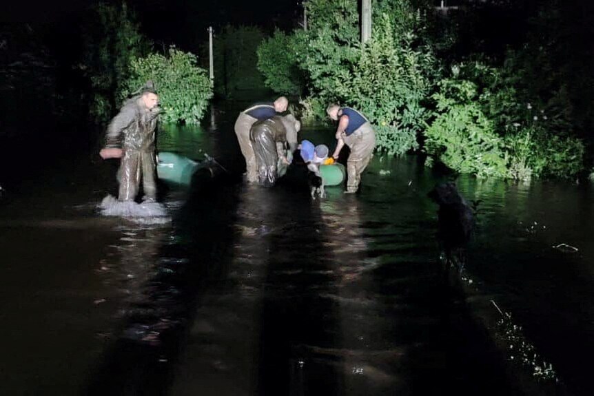 Rescuers help people to be evacuated from a flooded area