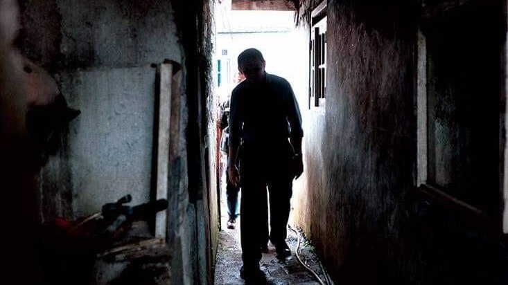 A man walking through a dark corridor