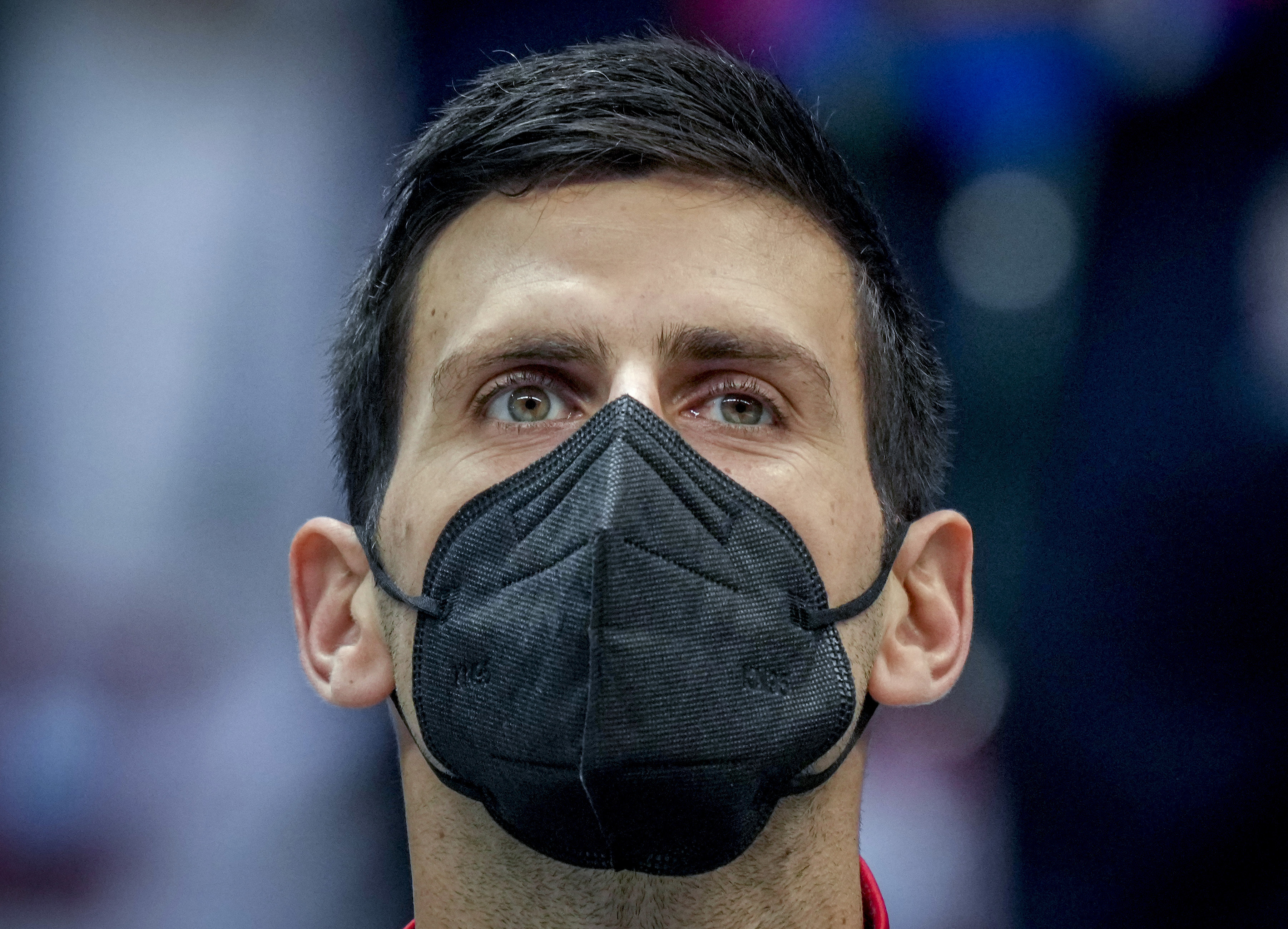 网球运动员诺瓦克·德约科维奇在听国歌时戴着黑色口罩。 “ class=
