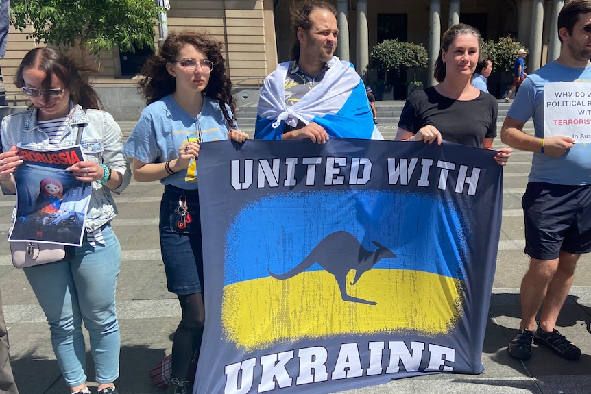 Protesters holding United with Ukraine flag.