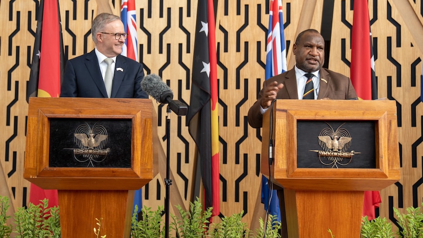 An image of two men standing at separate lecterns.