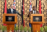 An image of two men standing at separate lecterns.