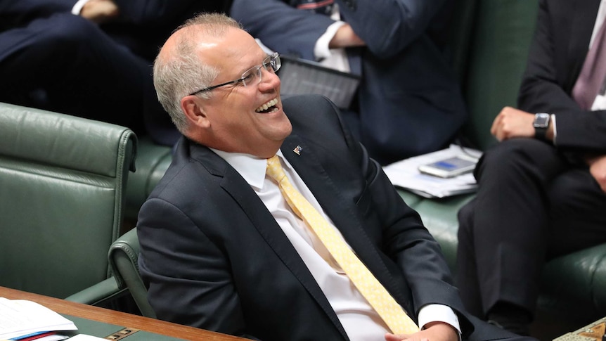 Morrison leans back in his chair having a laugh.