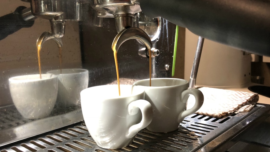 Coffee being poured through a handle in a coffee machine.
