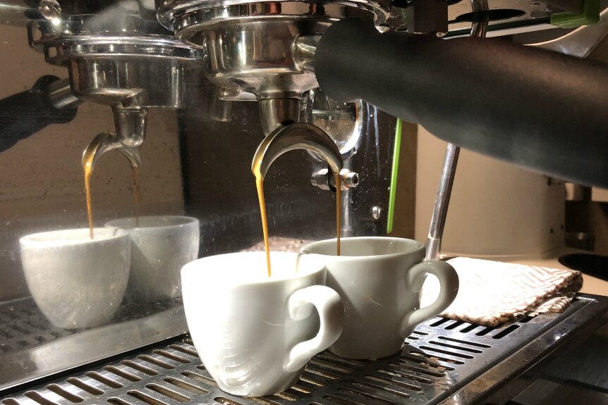 Coffee being poured through a handle in a coffee machine.