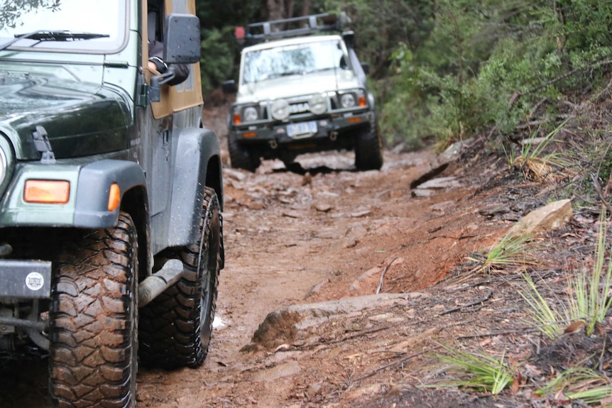 Four wheel driving enthusiasts driving down a muddy track in southern Tasmania