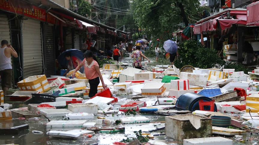 Residents clean up a flooded street in Xiamen, in China's eastern Fujian province after Typhoon Meranti made landfall on September 15, 2016.