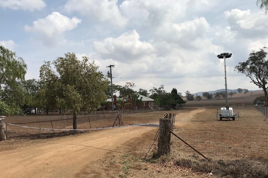 A country road with a home at the end.