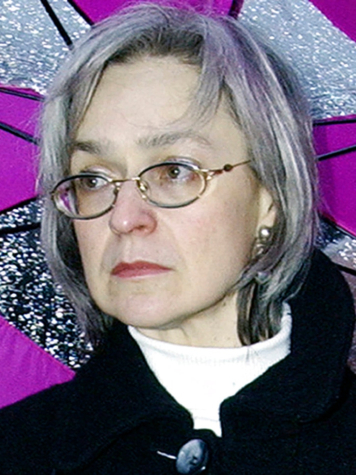 Anna Politkovskaya wearing silver framed glasses against a purple and silver background
