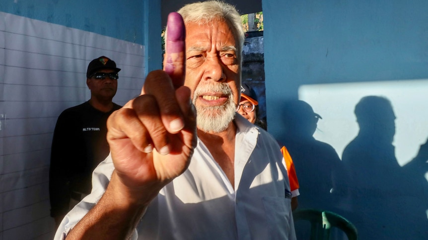 Xanana Gusmao holds up inked finger after voting