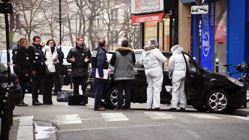 French police officers and forensic experts examine the car used by the armed gunmen