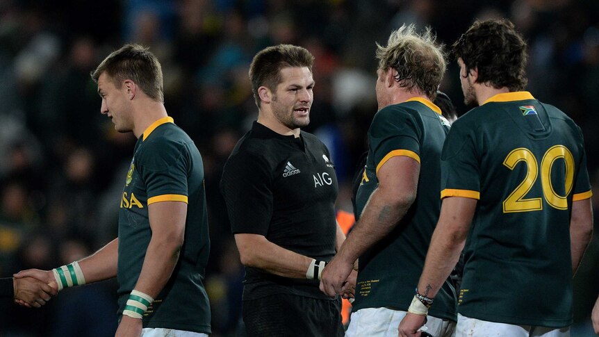 Close shave ... All Blacks captain Richie McCaw (C) shakes hands with his Springboks counterpart Schalk Burger