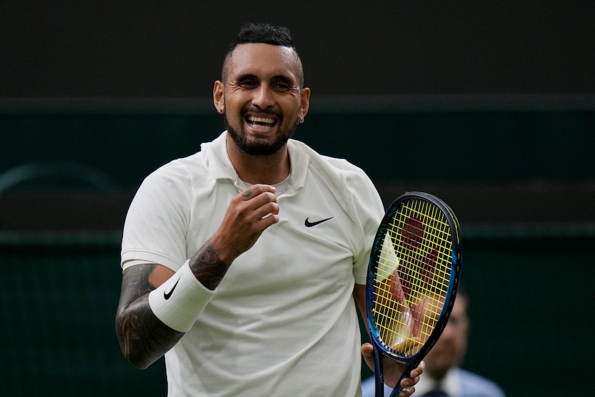 Nick Kyrgios smiles and clenches his fist in celebration during a match at Wimbledon.