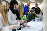 Election workers prepare ballots for counting.