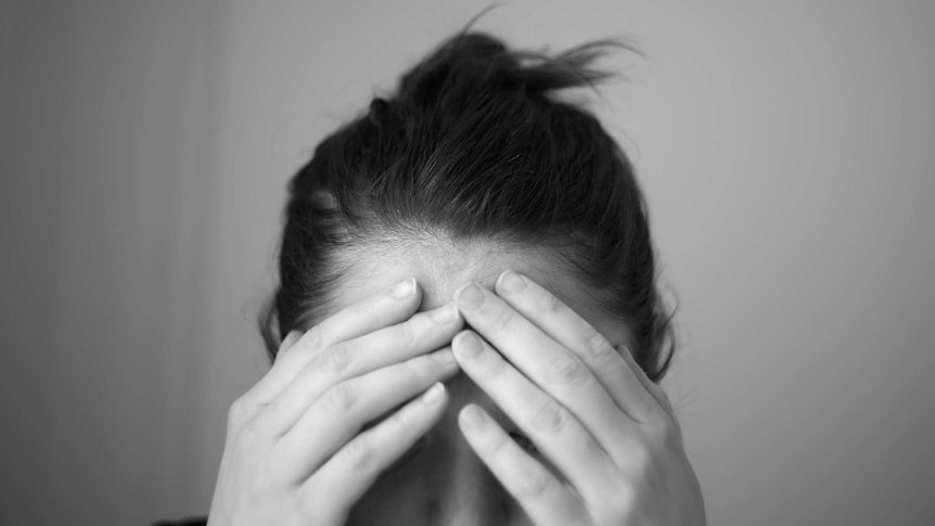 A woman puts her head in her hands