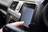 A mobile phone in a car-phone holder.