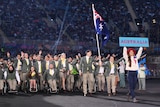 Australia marches behind a woman who is holding up a banner saying Australia