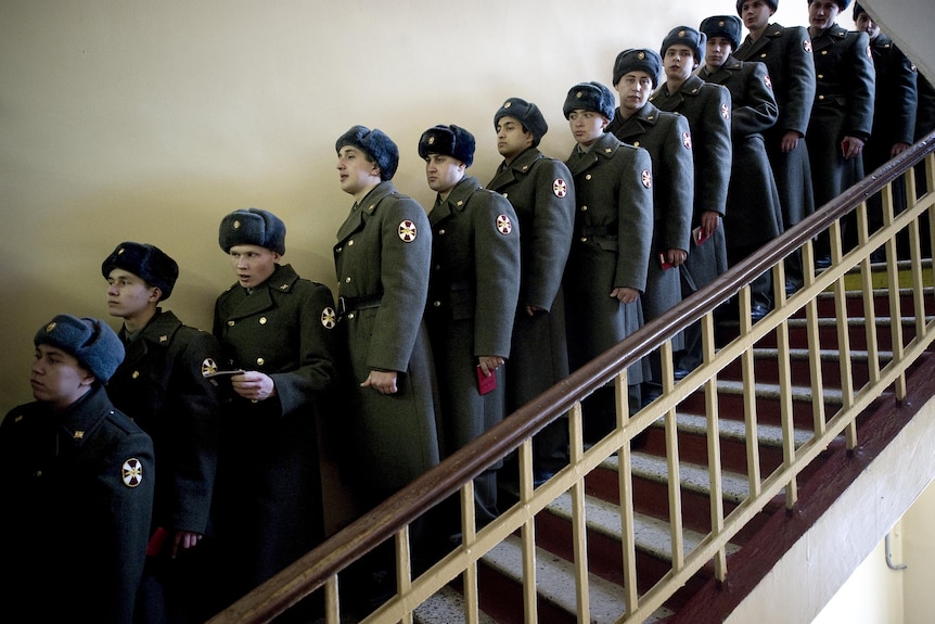 Russian soldiers stand in a queue at a polling station in Moscow.