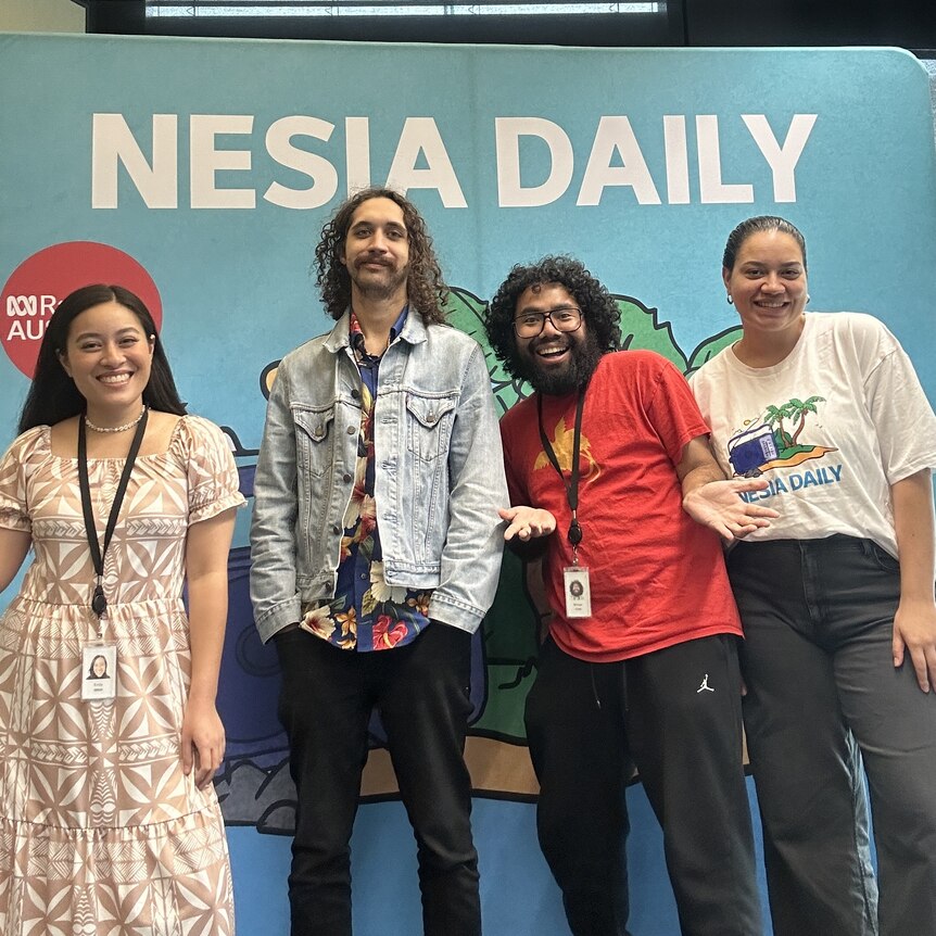 Two women and two men stand in front of a board that says Nesia Daily and smile