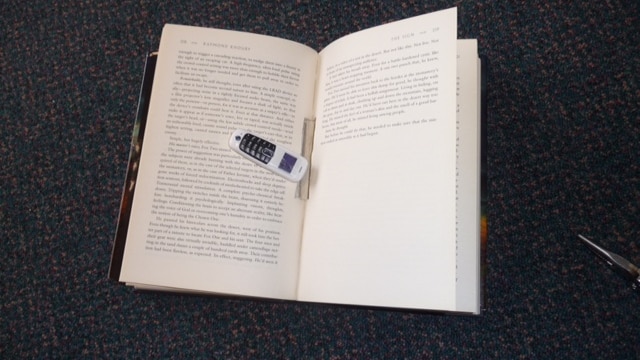 A mobile lies on an open book.