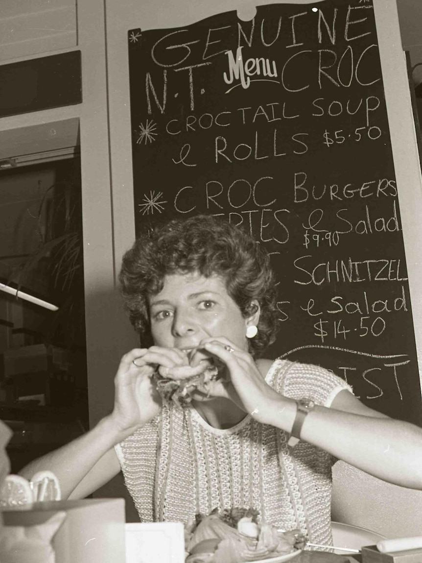A woman bites into a burger