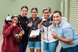 Science communicator Torres Webb and a group of indigenous students with smiles on their faces