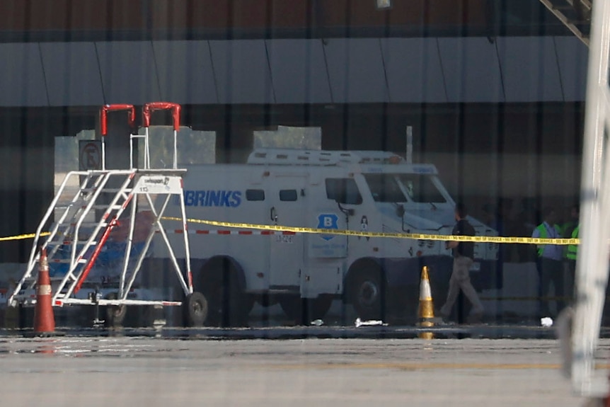 A white truck surrounded by yellow security tape.