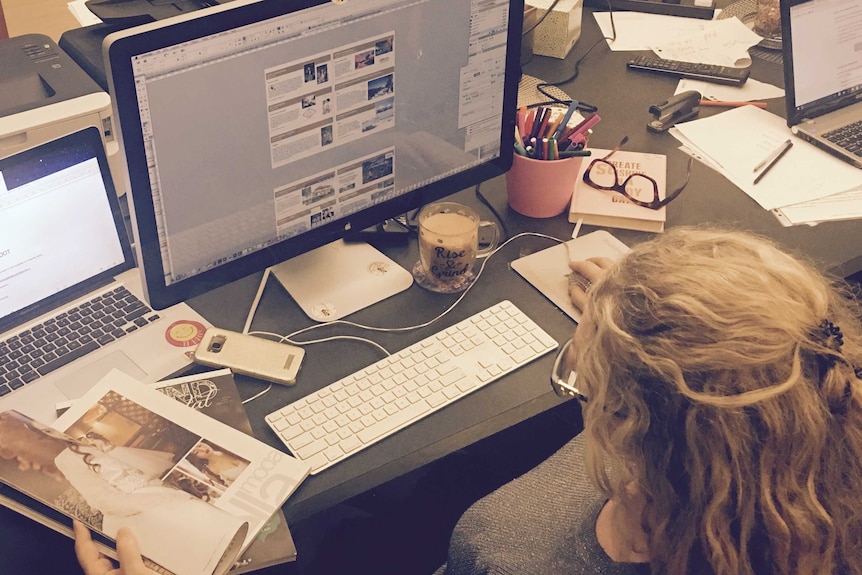 Back of woman's head overlooking computer